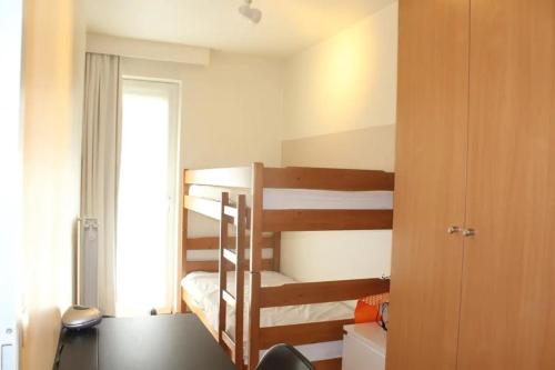 een kamer met 2 stapelbedden en een bureau bij Residentie Lautrec in Knokke-Heist