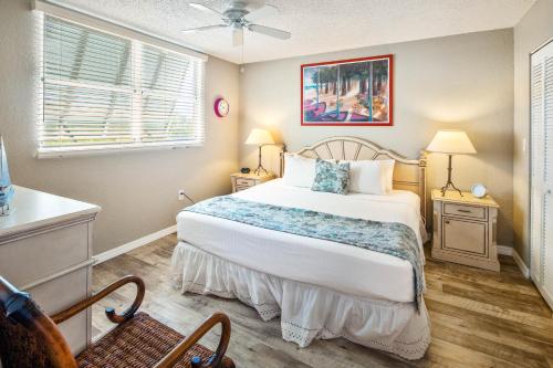 Un dormitorio con una cama grande y una ventana. en Sunrise Suites Tahiti Suite #104, en Key West