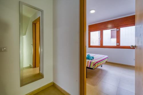 a bedroom with a mirror and a bed in a room at Vivalidays Urban Tossa House in Tossa de Mar