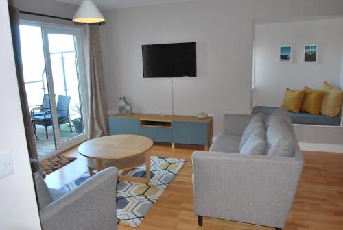 a living room with two chairs and a table at For the Shore, Fistral Beach Newquay - 2 Bed 2 bath - Private Parking with garage for 2 vehicles in Newquay