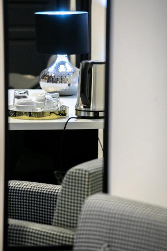 a mirror reflection of a table with a lamp and a chair at ALBA DEL CAPO in Palermo