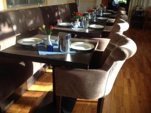 a long row of tables with plates and flowers on them at Hotel Pieter de Coninck in Westkapelle