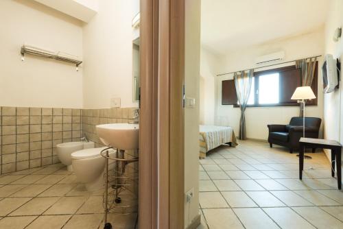 a bathroom with a sink and a toilet and a bedroom at Casale Belvedere vista mare in Valderice