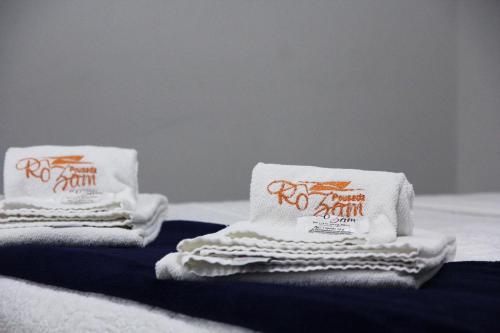 Dos toallas están encima de una cama. en Pousada Rozam, en Olímpia