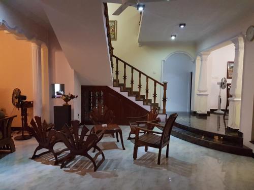 a room with a staircase and chairs and a table at Sri Lagoon Villa in Negombo