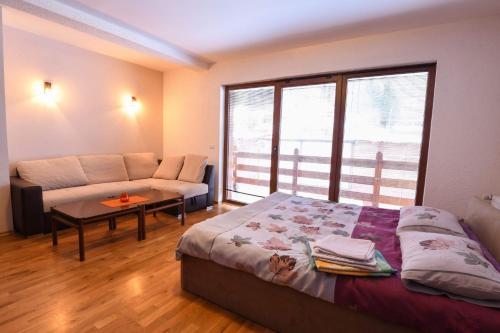 a bedroom with a bed and a couch and a window at Villa 'Iva' in Mavrovo