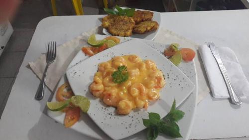 a plate of food with macaroni and cheese on a table at Cabañas y Restaurante Miss Elma in Providencia