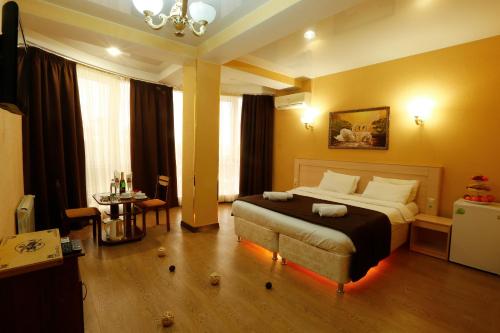 een slaapkamer met een groot bed in een kamer bij Golden House Hotel in Sotsji