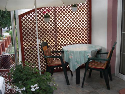 a table with two chairs and an umbrella on a patio at Apart Hévízi Ház in Hévíz