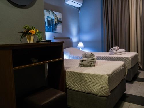2 łóżka w pokoju hotelowym z ręcznikami w obiekcie Gina's Studios w mieście Aliweri