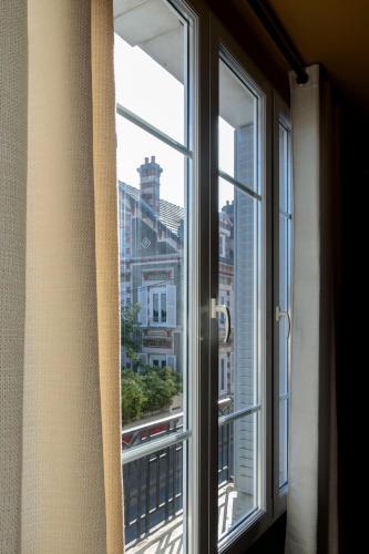 a window with a view of a city at L'HEURE BLEUE in Orbais