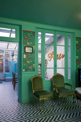 a green room with two chairs and a door at L'HEURE BLEUE in Orbais