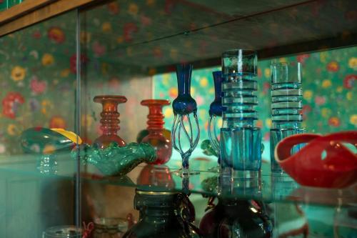 a group of glass vases sitting on a glass shelf at L'HEURE BLEUE in Orbais
