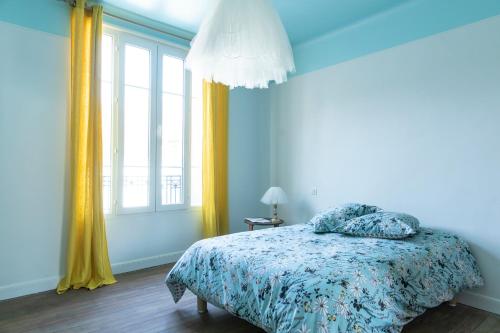 a bedroom with a bed and a large window at L'HEURE BLEUE in Orbais