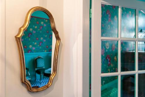 a mirror hanging on a wall next to a window at L'HEURE BLEUE in Orbais