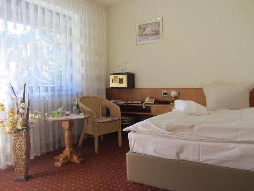 a hotel room with a bed and a desk and a window at Ferienhotel Schwarzwälder Hof in Feldberg