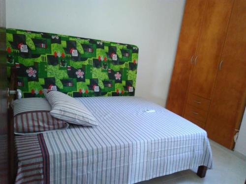 1 dormitorio con 1 cama con manta verde y blanca en Ótimo apto Praia Bessa, en João Pessoa