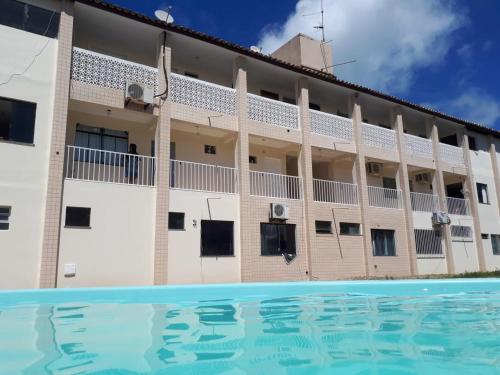 a hotel with a swimming pool in front of a building at Ap aluguel no Guaibim in Guaibim