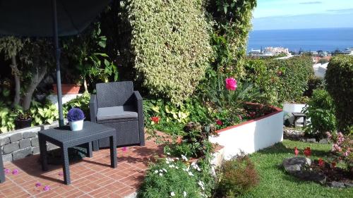a patio with a chair and a table and flowers at Apartments Vista Oceano in Funchal