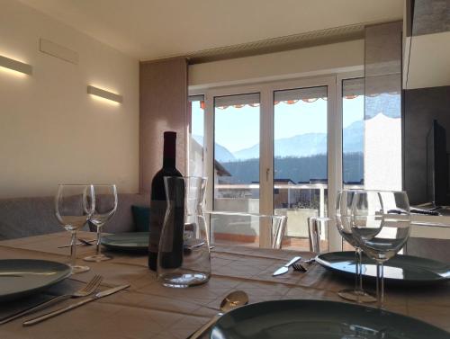 a table with a bottle of wine and wine glasses at Casa Lu in Levico Terme
