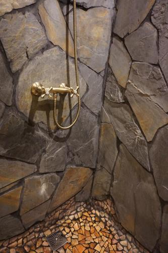 a stone wall with a shower in a bathroom at CASA DEL ARTE casa rural in Chulilla