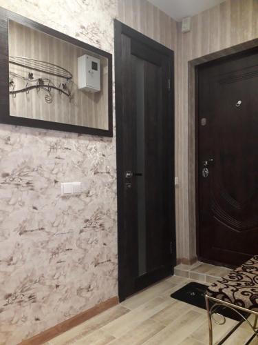 a room with a black door and a stone wall at Apartment 30 m2 on Sergei Esenin 11 in Kharkiv