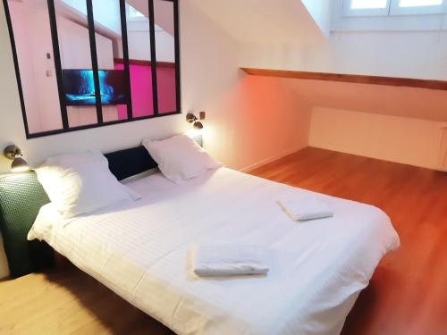 une chambre avec un lit blanc avec deux serviettes dessus dans l'établissement Chez Muriella & Marco, à Lyon