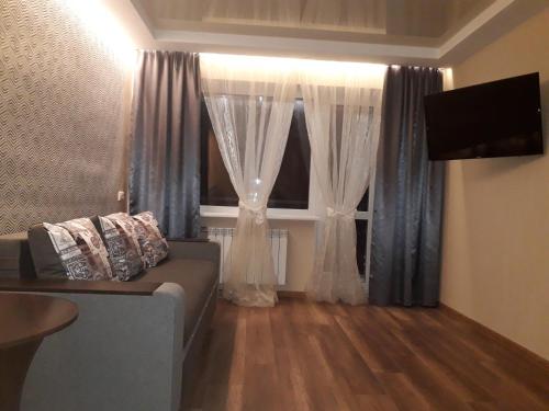 a living room with a couch and a window at Apartment 30 m2 on Sergei Esenin 11 in Kharkiv