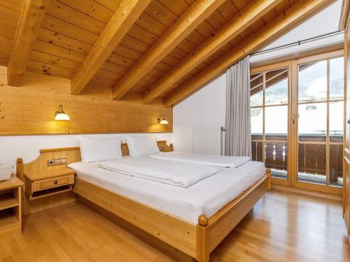 a bedroom with a large bed in a room with wooden ceilings at Gästehaus Bergwinkl in Reit im Winkl