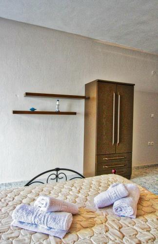 a bedroom with two pairs of slippers on a bed at Arianna Studios 7 in Kavála