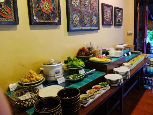 a buffet line with plates and bowls of food at Baantawan Guesthouse Pai in Pai