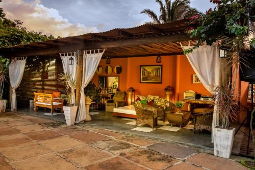 a patio with a bed and curtains and a table at Pousada Sítio Ipê in Viçosa do Ceará