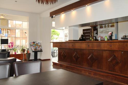 a bar in a restaurant with a counter and chairs at New City Hotel Scheveningen in Scheveningen