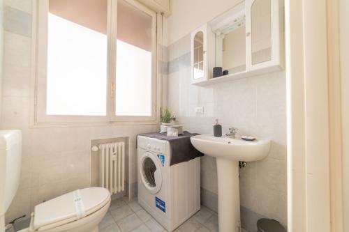 een badkamer met een wasmachine en een wastafel bij Bologna Fiera Fani Apartment in Bologna
