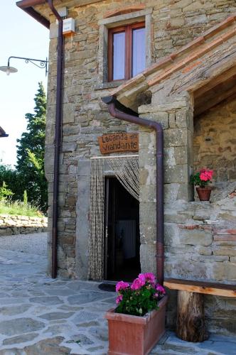 a stone building with a door with flowers in front at Locanda Del Viandante B&B in Anghiari