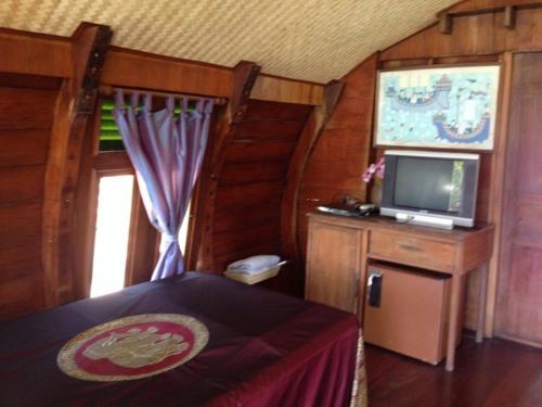 a bedroom with a bed and a tv in a room at Ayothaya Riverside House in Phra Nakhon Si Ayutthaya