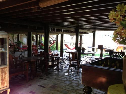 a dining room with tables and chairs and a table at Ayothaya Riverside House in Phra Nakhon Si Ayutthaya