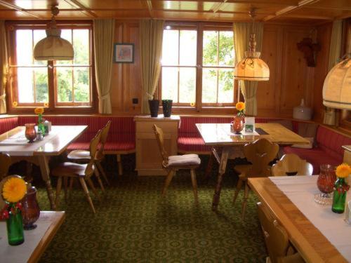 a dining room with tables and chairs and windows at Land- & Panoramagasthof Schöne Aussicht in Viktorsberg