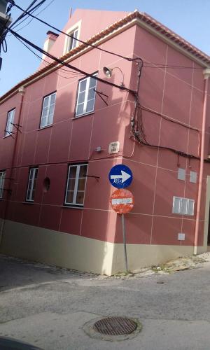 a red building with a street sign in front of it at Aliciamar E by Casas de Setúbal in Setúbal