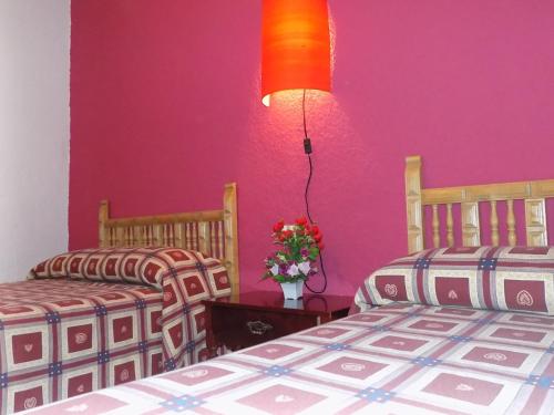 two beds in a room with pink walls at Fuente Del Gamellon in Buenache de la Sierra
