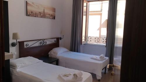 mały pokój z 2 łóżkami i oknem w obiekcie Vertex Palace w Rzymie