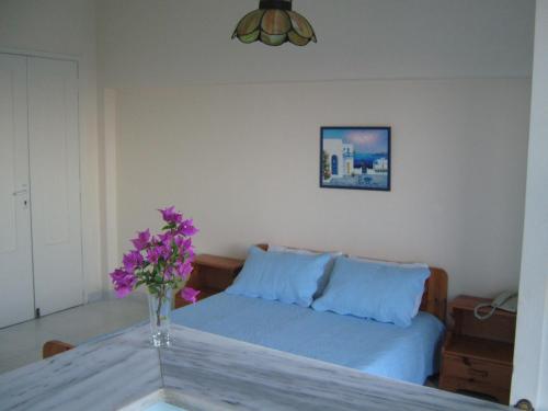 sala de estar con sofá y jarrón con flores púrpuras en Villa Anneta, en Kamari