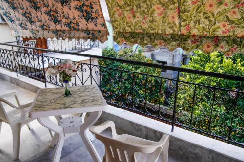 a table with a vase of flowers on a balcony at Myrto's Apartment No15 in Loutra Oraias Elenis