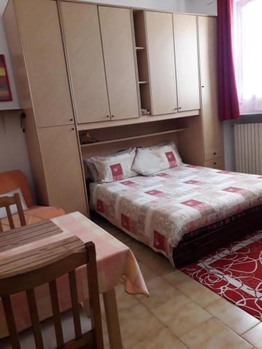 sypialnia z łóżkiem z białymi szafkami i stołem w obiekcie Appartamento "Da Mamma Agnese" w mieście Gorgonzola