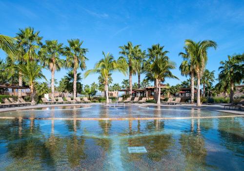 a swimming pool with palm trees in a resort at Villa del Palmar at the Islands of Loreto in Loreto