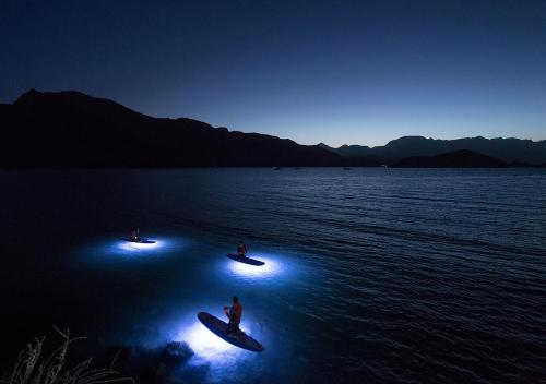 two people on surfboards in the water at night at Villa del Palmar at the Islands of Loreto in Loreto