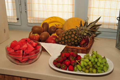 a counter with a basket of fruit and a bowl of strawberries at Scala Apartments in Kastraki Naxou