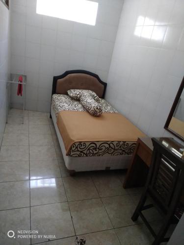 a small bedroom with a bed in a room at Rumah Retret Bethania in Kuta