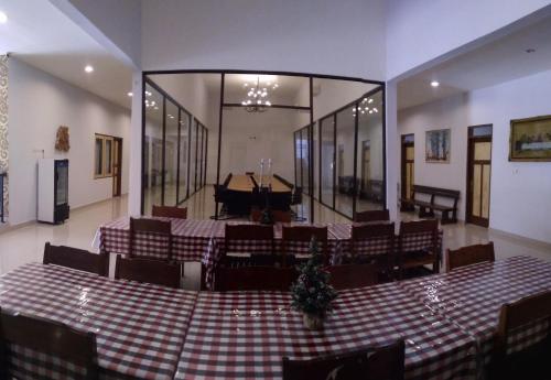 a room with a table and chairs and a grand piano at Rumah Retret Bethania in Kuta