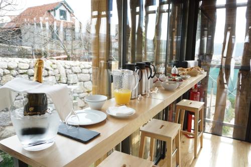 a table with food and drinks on it in front of a window at Muralha Charm House in Lamego
